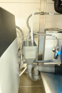 Anschluss einer professionellen Haubendurchschubspülmaschine mit offenem Trichtersiphon, Ablauf und Anschluss für ein Wasseraufbereitungssystem (Enthärtungsanlage).
