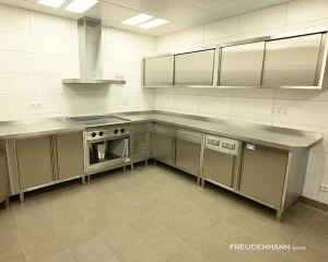 Individuell gefertigter Edelstahl-Unterbauschrank für die Großküche mit integrierten Steckdosen für elektrische Küchengeräte.