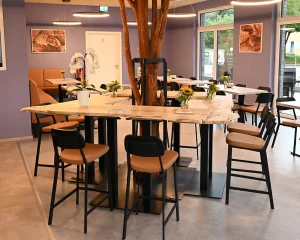 Zentraler Stehtisch mit Kunstbaum und umlaufender Tischplatte in amerikanischer Höhe in der BrotBotschaft Bretten