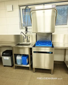 Meiko Durchschubspülmaschine Upster H 500 mit Zulauftisch und Schlauchpendelbrause zur effizienten Vorspülung von Geschirr.