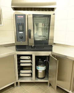 Rational Kombidämpfer auf Edelstahl-Arbeitsplatte mit vorgeschaltetem Wasseraufbereitungssystem für den professionellen Einsatz in der Großküche.